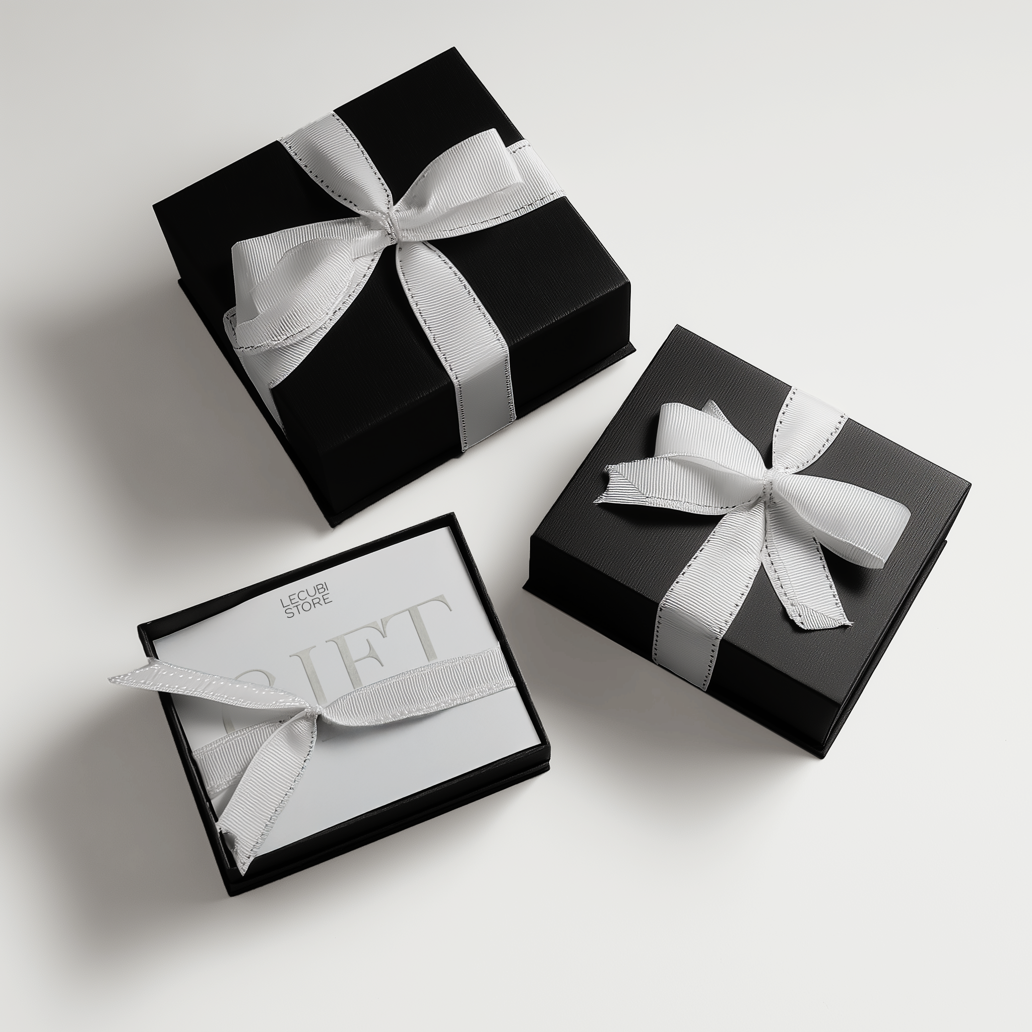 black and white top-down birdview mockup of three paper white gift cards with the same design inside black boxes as frames, with decorative ribbons lying differently around each box. ribbons have white decorative stitching for a polished look. 