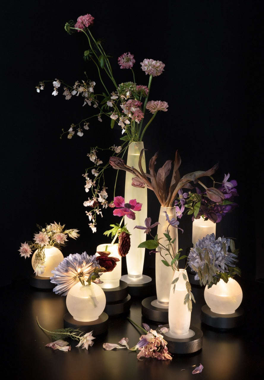 Serax Vase/Lampe Lara – im Ensemble mit LYS-Varianten und Blumen, stimmungsvolle Szene